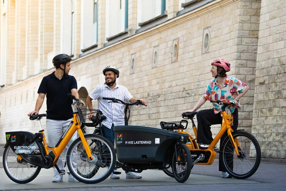 Verschiedene Leihfahrräder und männliche Radfahrer.
