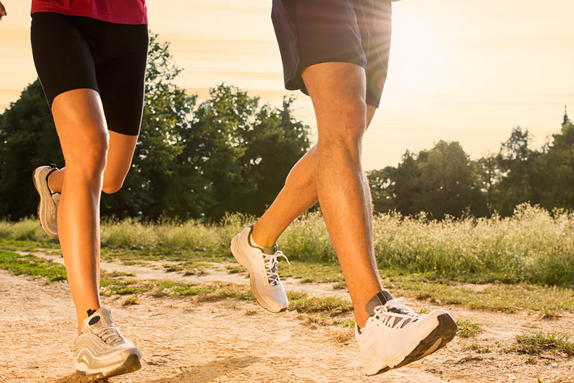 Крака на жена и мъж, които тичат