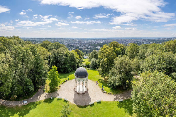 Der Nerobergtempel vor dem Hintergrund Wiesbadens an einem sonnigen Tag.