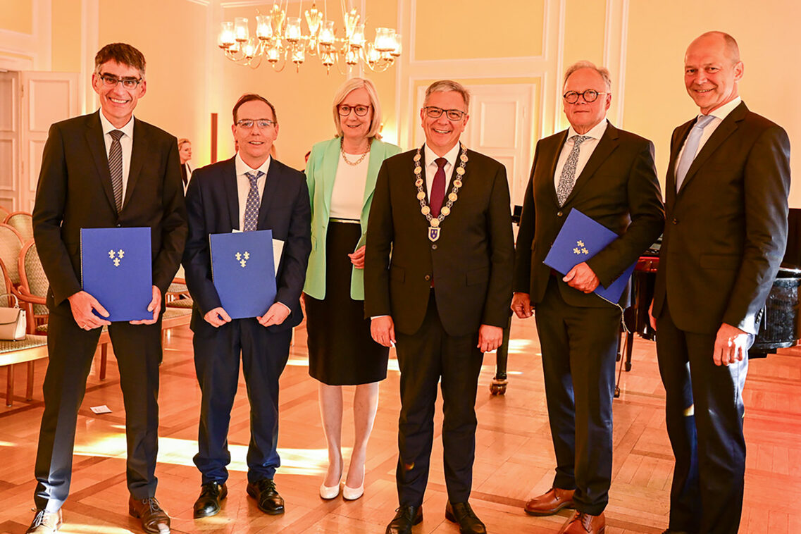 Eine Frau und fünf Männer bei einer Preisverleihung.