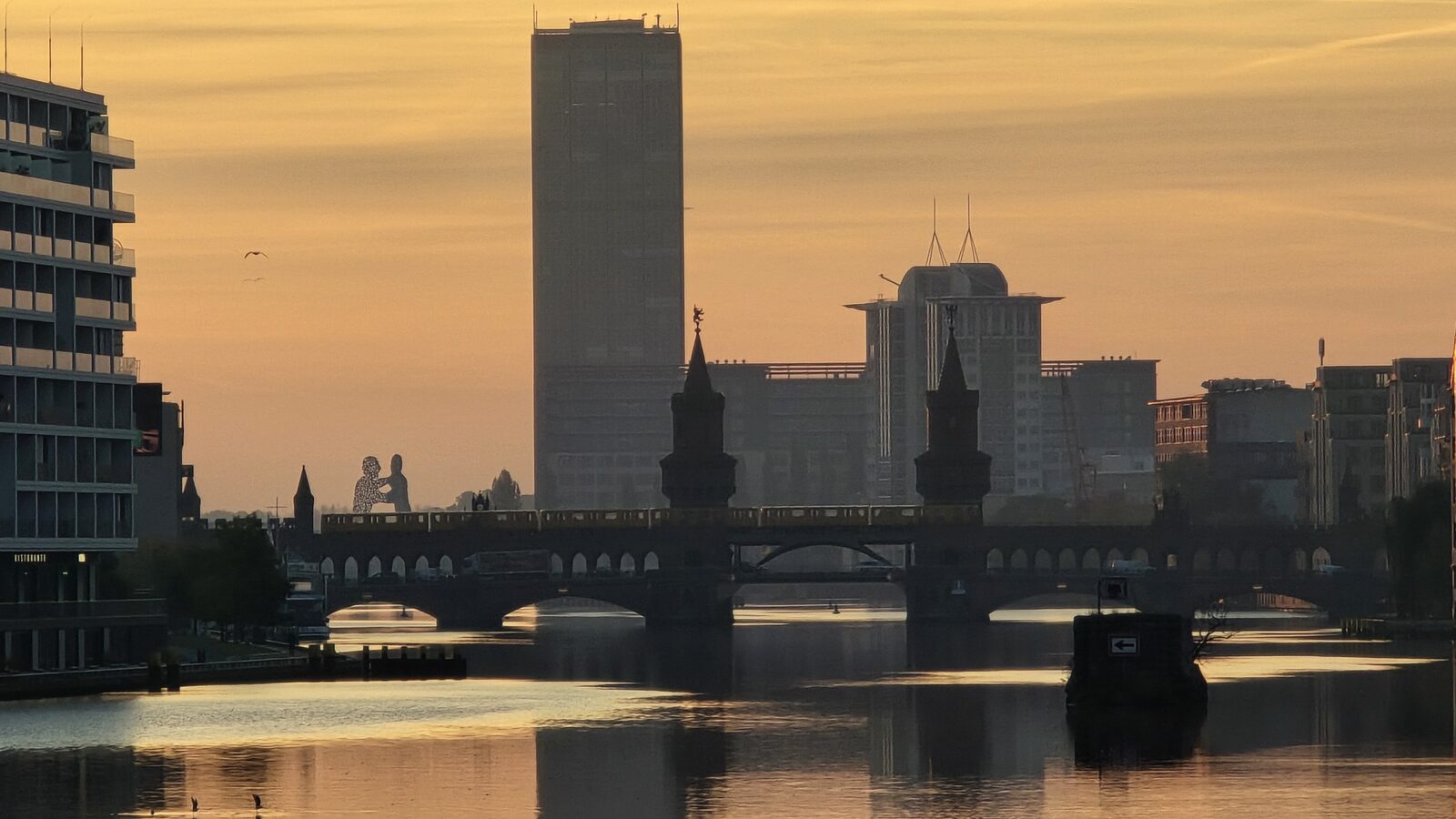 Ein Fluss mit modernen Gebäuden und einer historischen Brücke