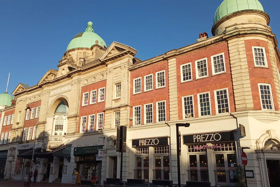 Clădire istorică cu turnulețe pe un cer albastru.