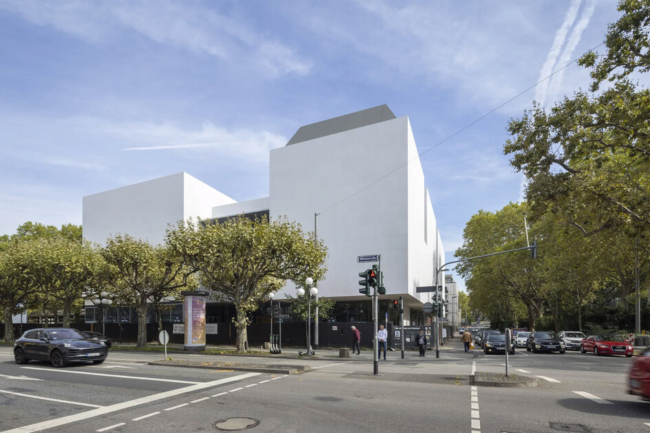 modernes Gebäude in weiß mit Bäumen davor.