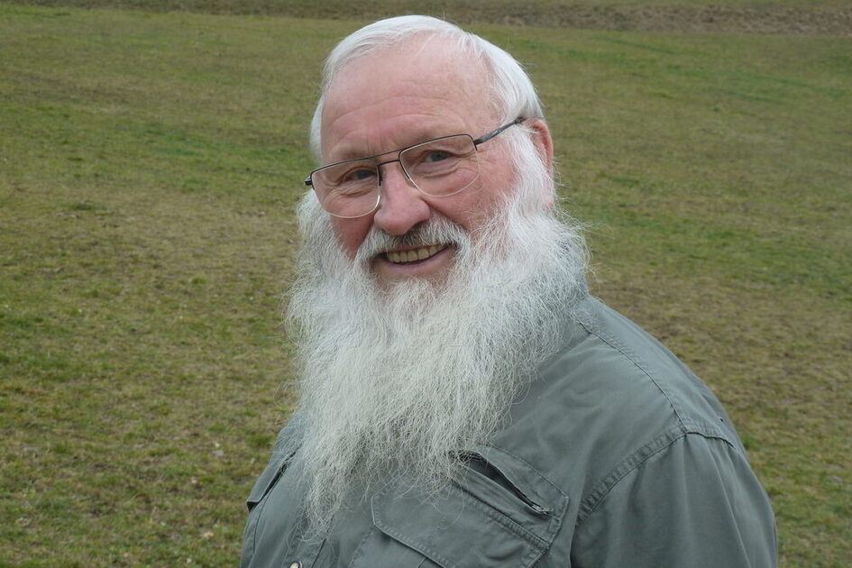 Portrait von Professor Dr. Peter Berthold, er steht auf einer grünen Wiese.