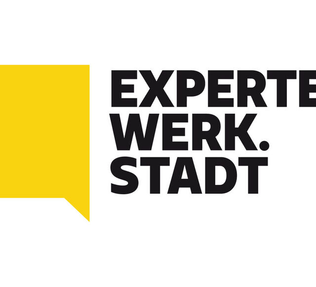 شعار بفقاعة خطاب صفراء كبيرة بزاوية صفراء على اليسار وبجانبها عبارة "Expertenwerk.Stadt" بأحرف كبيرة موزعة على ثلاثة أسطر