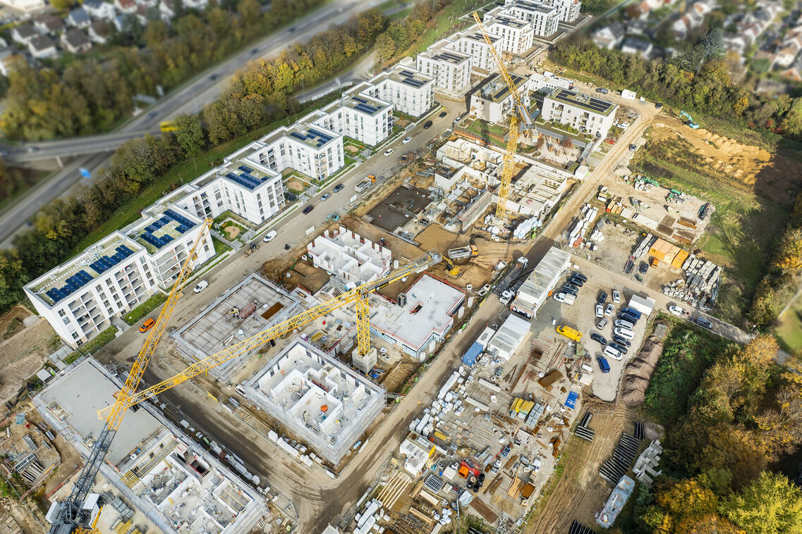 Drohnenaufnahme zeigt aus südlicher Blickrichtung, dass die Bebauung entlang der Saarstraße bereits fertiggestellt ist und die sich anschließenden Mehrfamilienhäuser sich im Bau befinden.