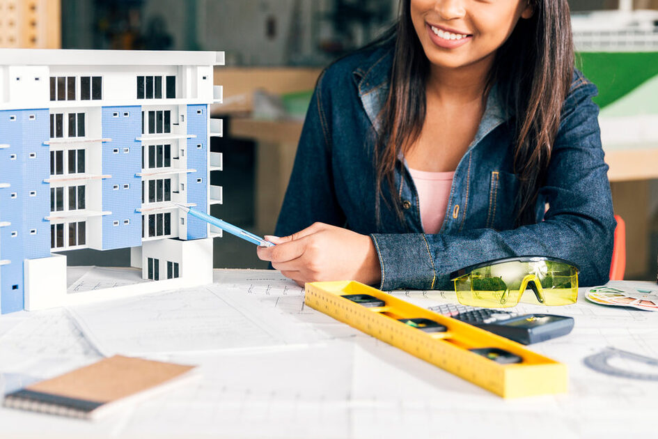 Architektin am Planungstisch mit Modell