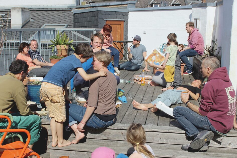 Gruppe von Menschen auf Dachterrasse sitzend