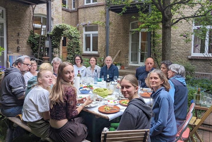 Gruppenfoto am Esstisch im Hof