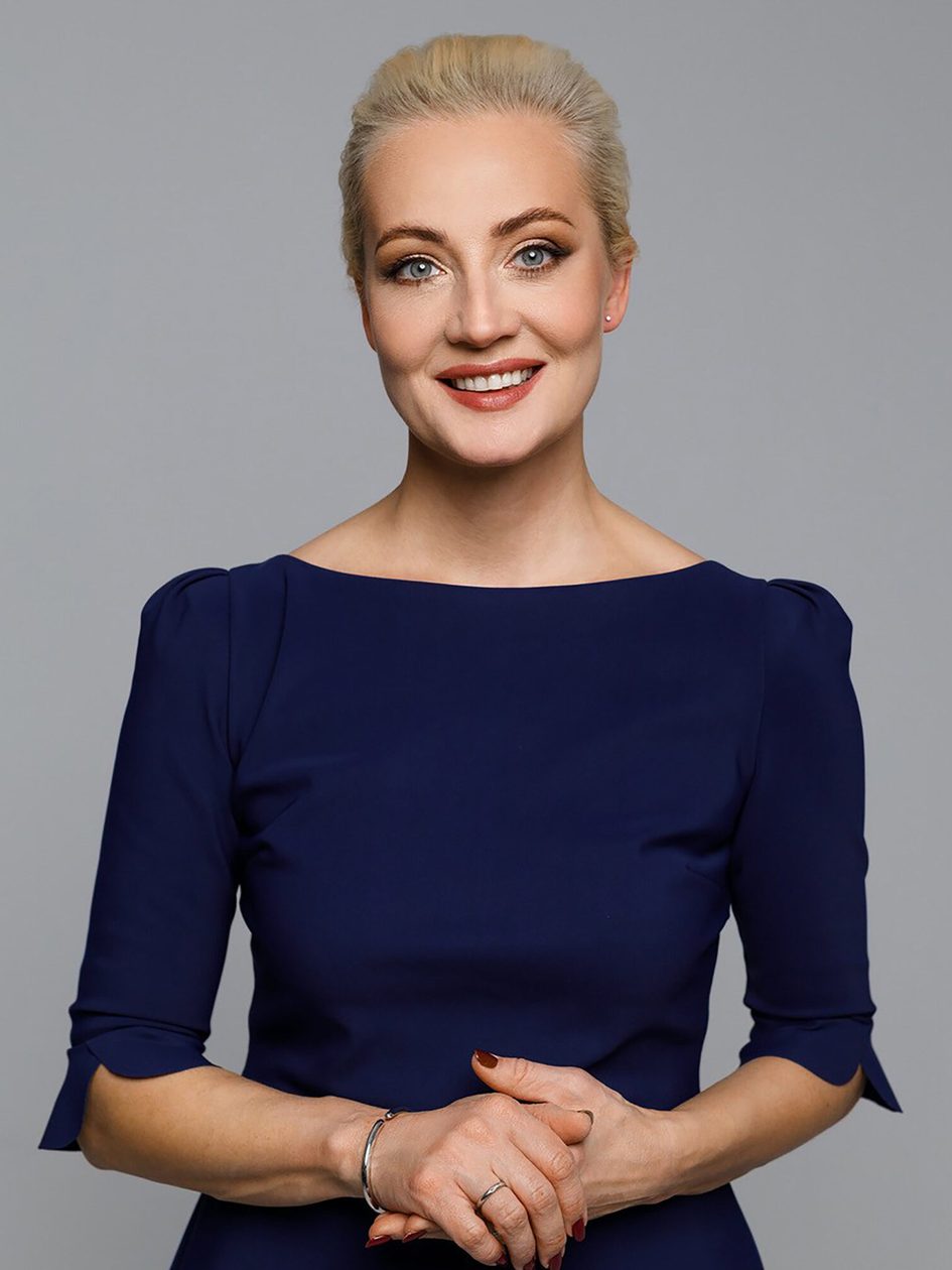 Frau mit blonden Haaren und blauem Kleid.