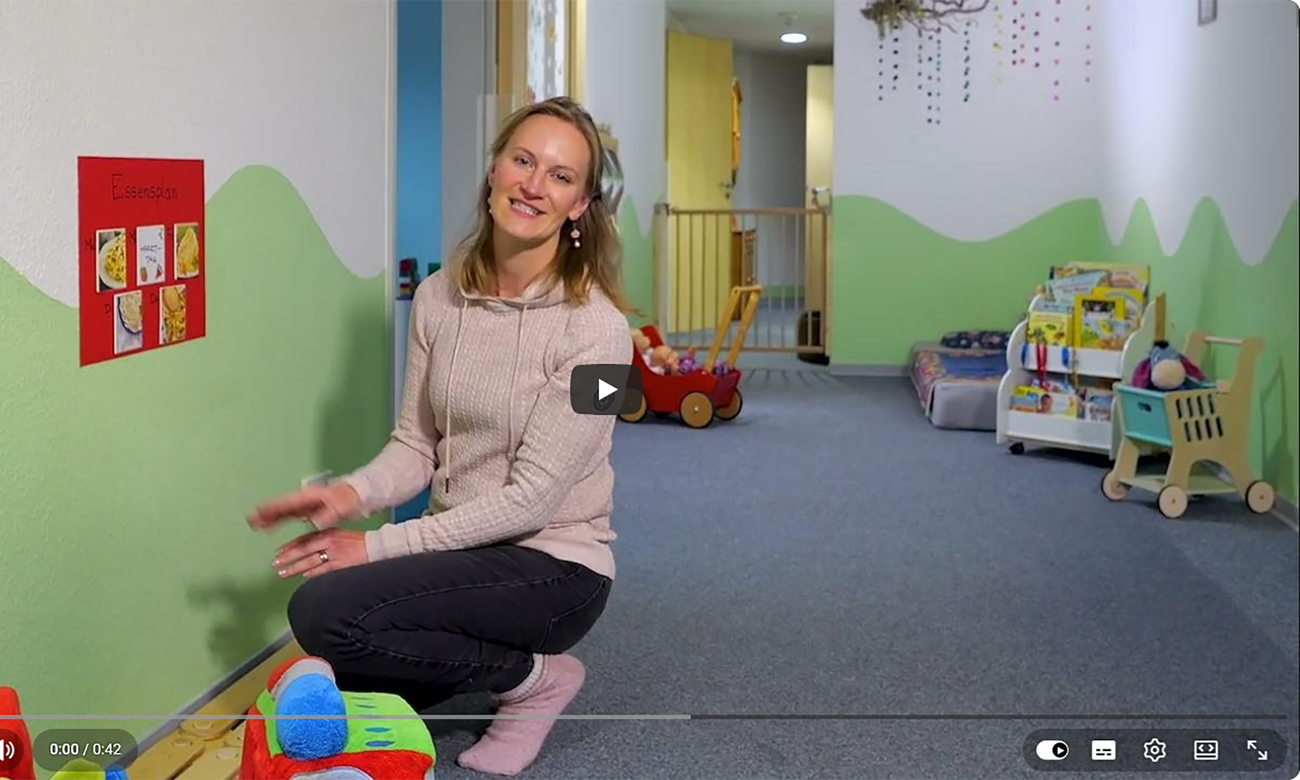 Das Video startet mit einem Kind, dass lächelnd in die Kamera schaut und fragt freudig, was es heute in die Kindertagespflegestelle zu Essen gibt.