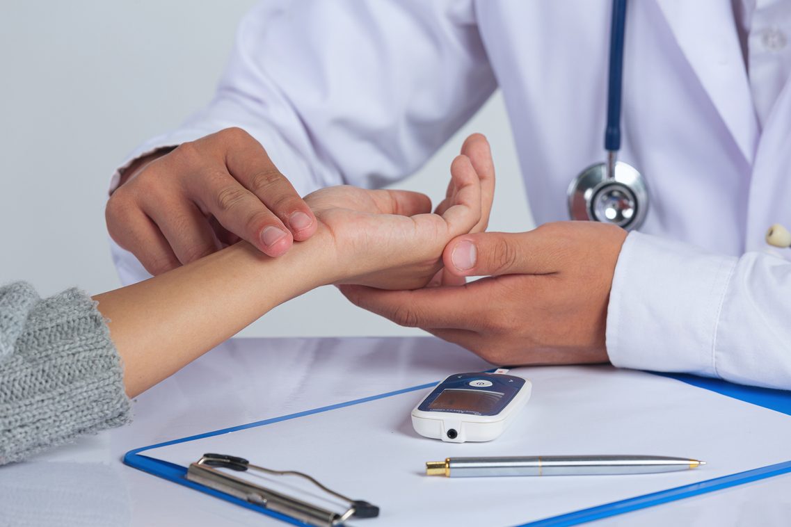 Arzt prüft Puls bei Patient