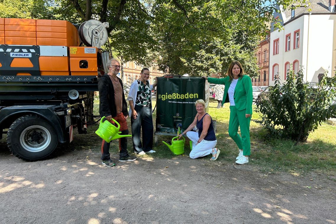 Persone davanti a un grande container con la scritta "gießbaden".