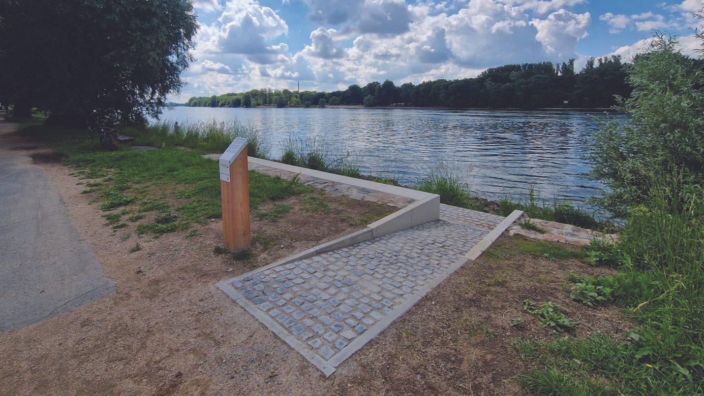 Sitzstufe am Rheinufer mit Blick aufs Wasser.