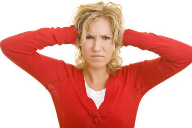 Frau hält sich beide Ohren zu