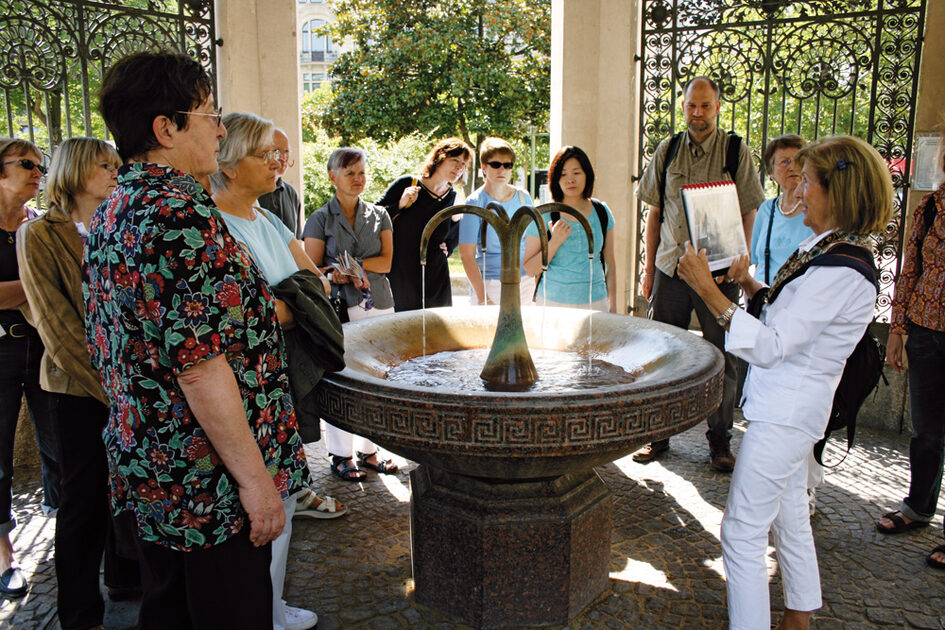 Eine Stadtführung versammelt um den Kochbrunnen.
