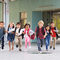Grundschulkinder laufen einen Gang entlang in Richtung Kamera