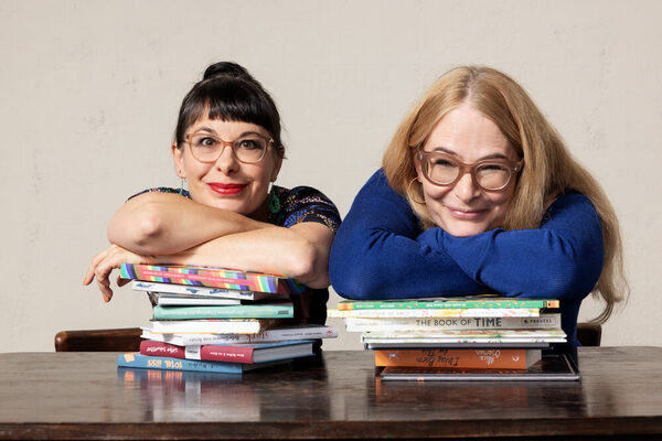 Two women lean on books