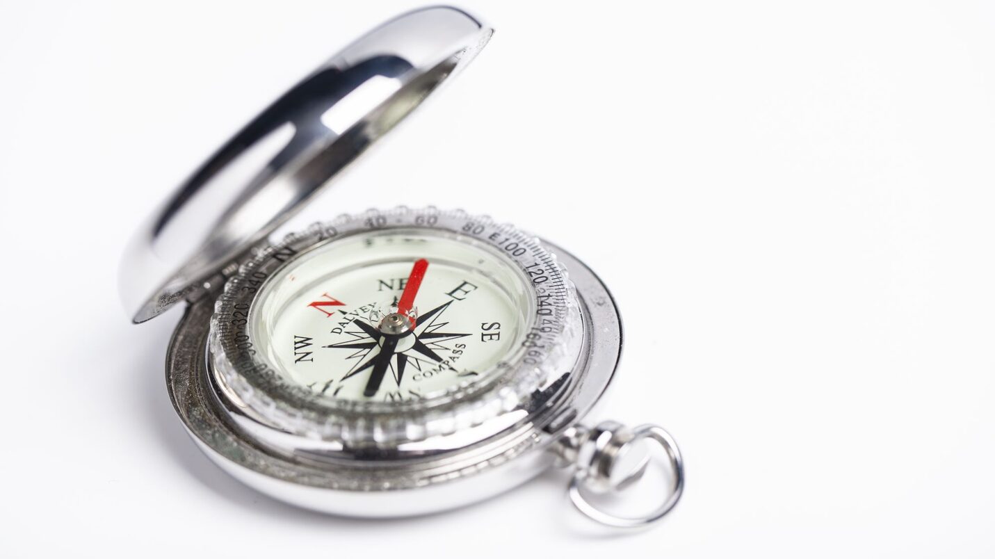 Ein silbener Kompass der auf Nordost zeigt.
