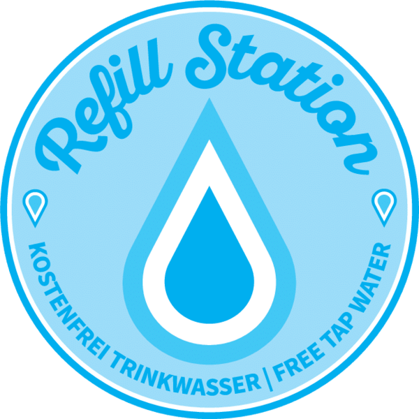Autocollant bleu rond en haut Écriture : Refill Station, en dessous se trouve une goutte d'eau stylisée et en bas le texte Gratuit Eau potable