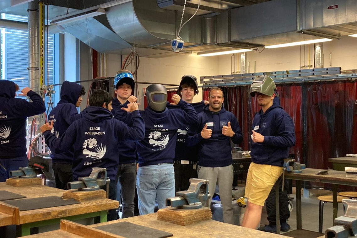 Junge Menschen stehen in einer Werkstatt