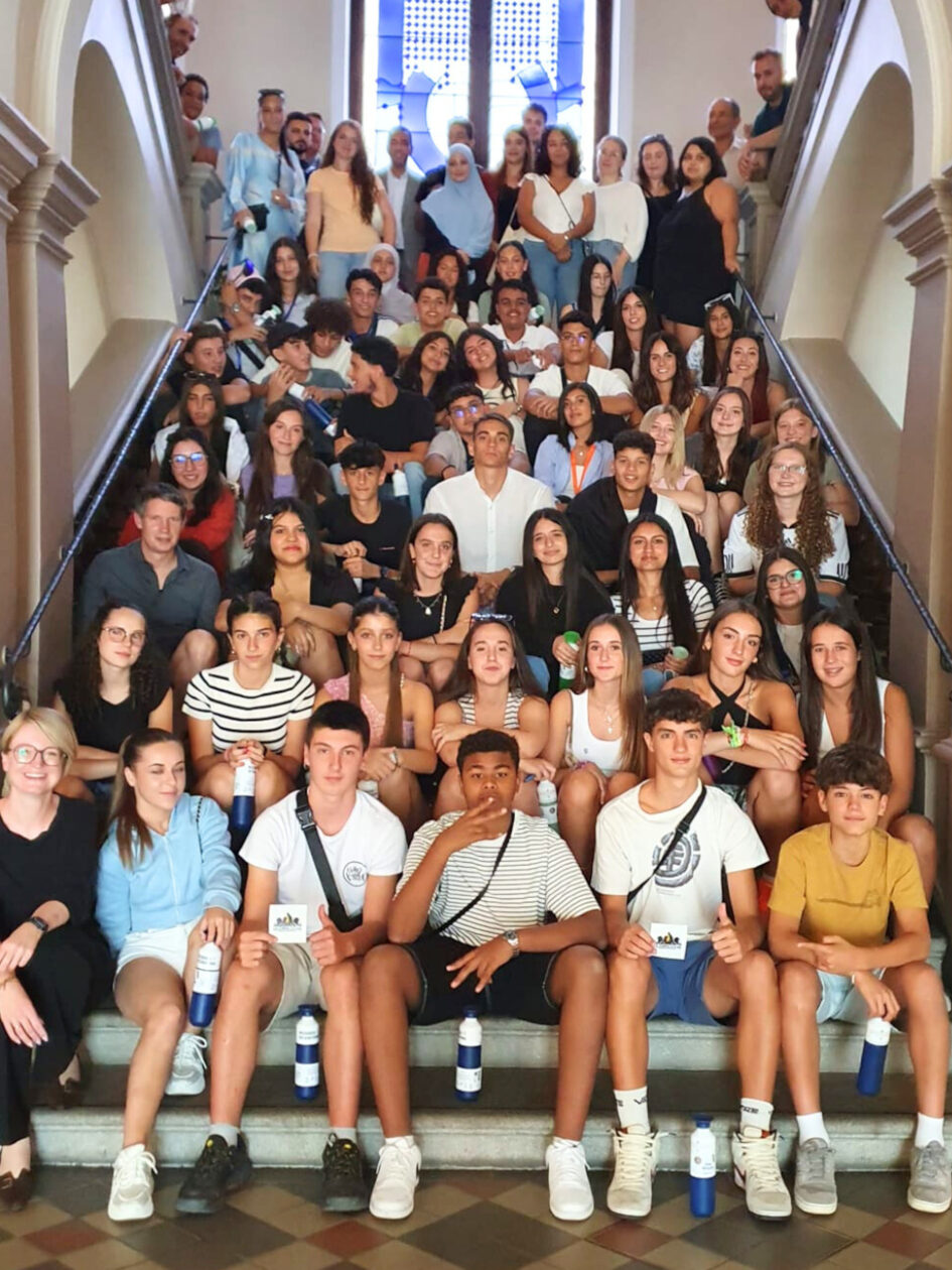 Auf einer Treppe sitzen viele Jugendliche aus verschiedenen Ländern.