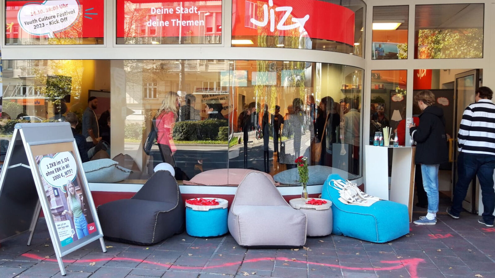 I sacchi di fagioli blu, grigi e neri si trovano davanti alla vetrina di un negozio. Uno striscione in alto recita "JIZ".