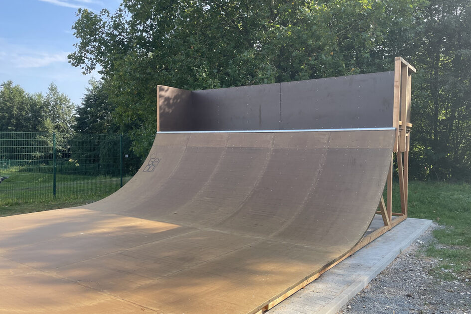 Eine Skaterampe steht auf einer Wiese.