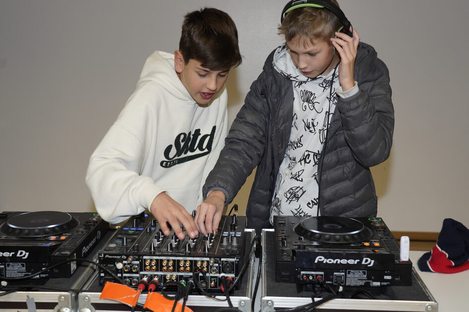 Zwei Jungend stehen an einem Mischpult.
