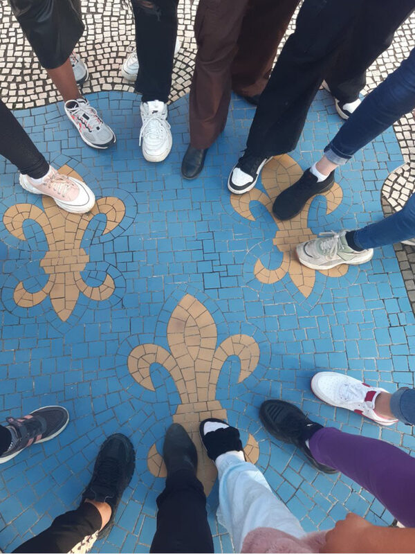 Feet stand on a paved floor with a lily.
