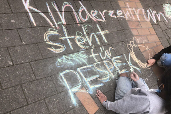 Schrift mit Kreide auf Pflasterboden