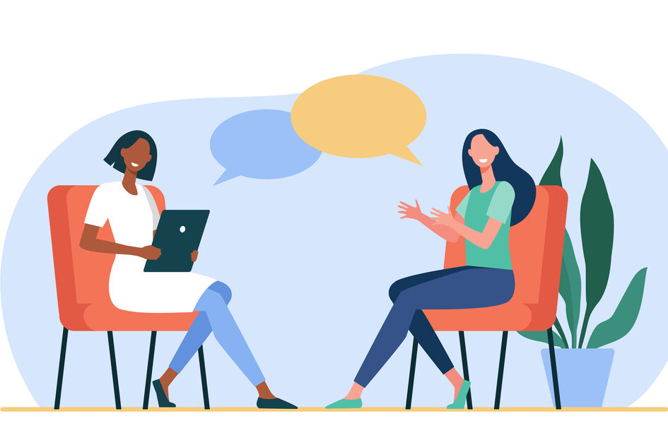 Two women sit opposite each other and talk.