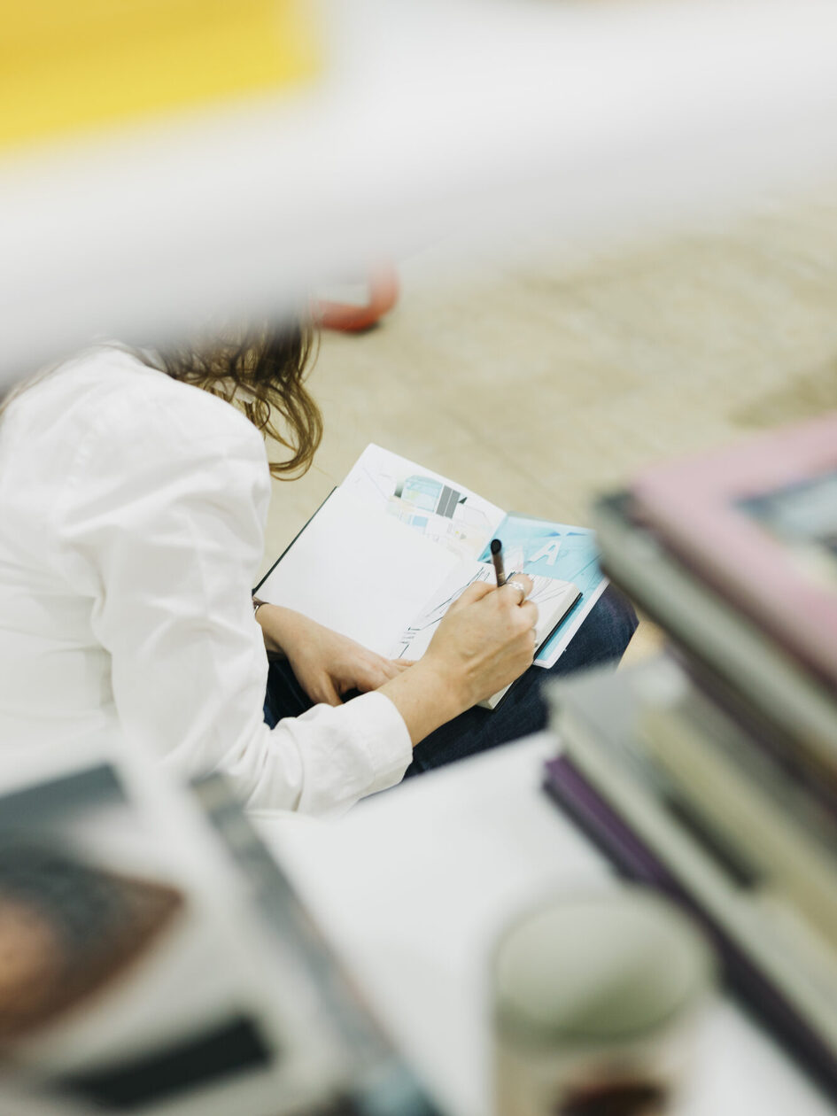 Eine Frau schreibt in ein Buch.