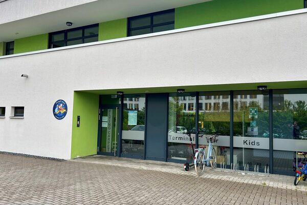 The entrance area of the daycare center - a round sign with the logo on the left wall