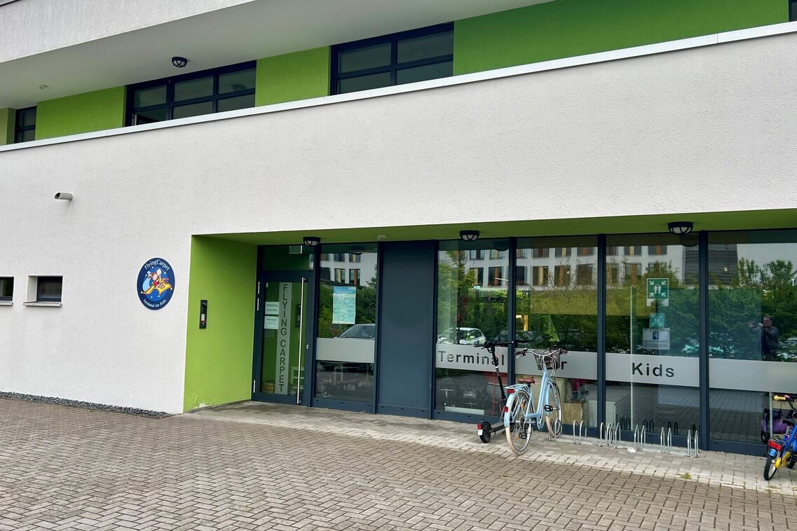 Der Eingangsbereich der Kindertagesstätte - links an der Wand ein rundes Schild mit dem Logo