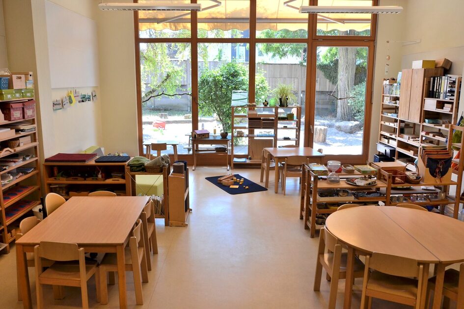 A group room at the daycare center with small tables and chairs