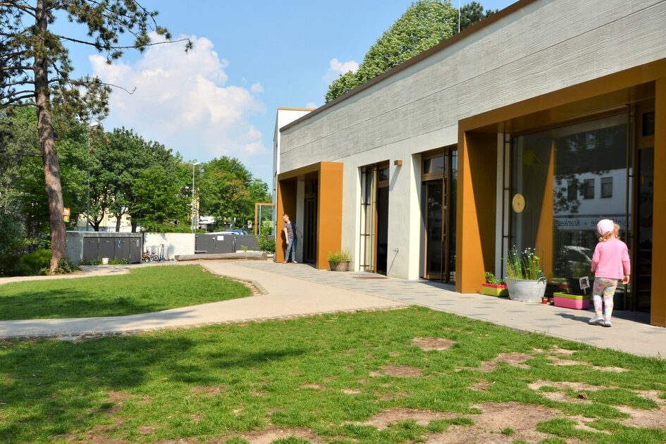 Das Außengelände der Kita. Auf der rechten Seite steht das Gebäude mit großen Fensterfronten