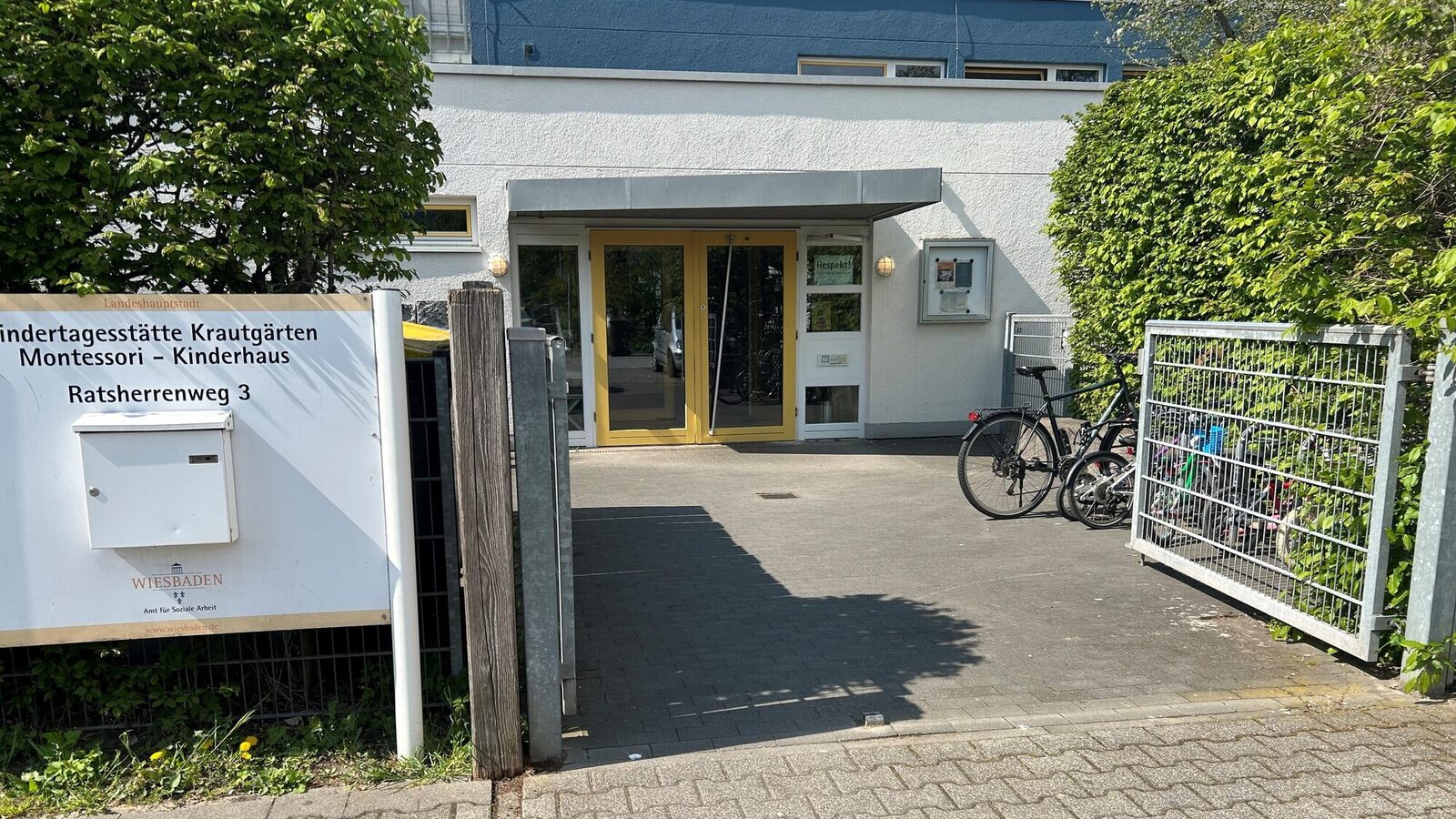 Der Eingang der Kindertagesstätte - links steht ein Schild mit dem Namen