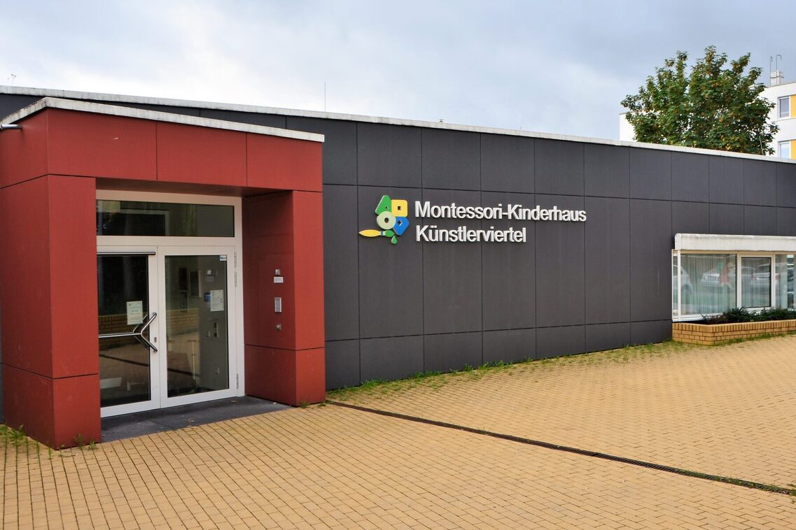 Das Gebäude der Kindertagesstätte mit dem Eingang in einem rot umrandetem Vorbau.