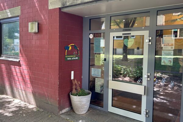 Входът на дневния център. В левия ъгъл има саксия, над която е изобразено логото на детската градина с надпис