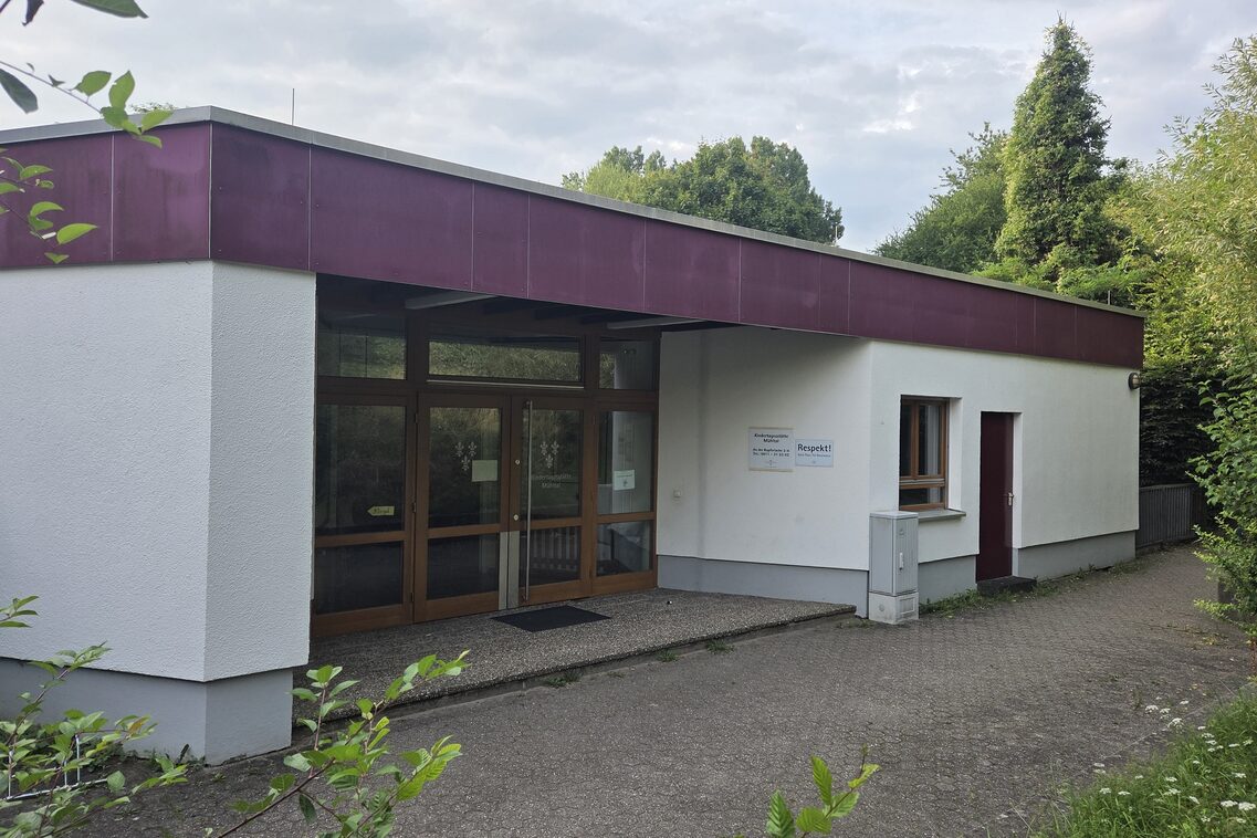 The entrance area of the daycare center. In the background are tall trees