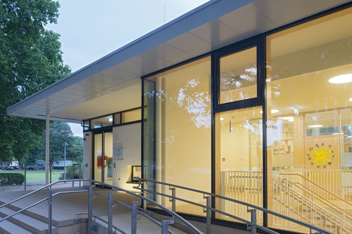 Die hell erleuchtete fensterfront des Eingangs der Kindertagesstätte