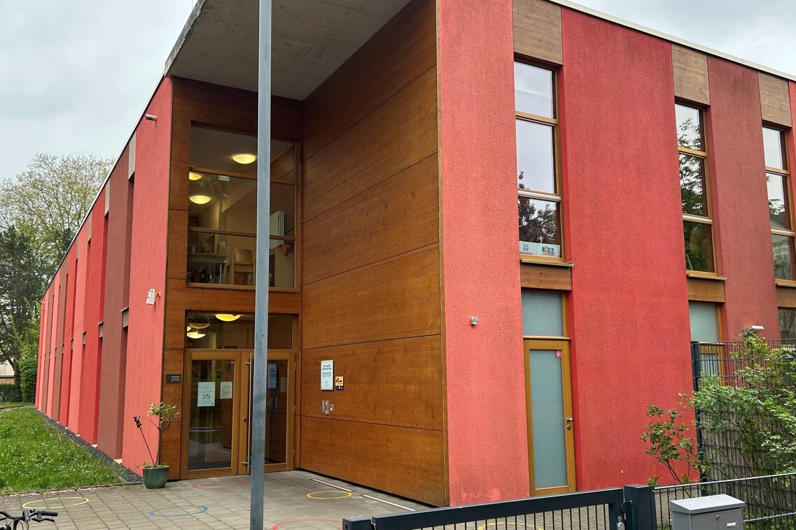 Ein rotes Gebäude mit dem Eingang der Kindertagesstätte