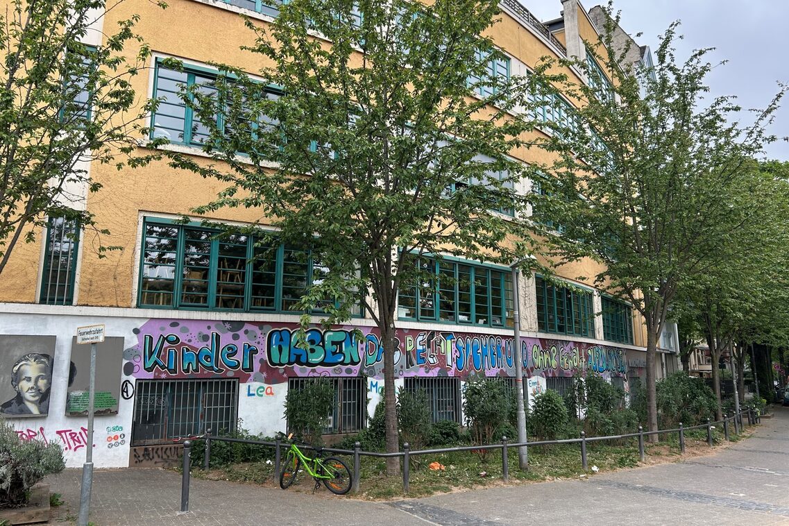 Die Längsseite der Kindertagesstätte, ein Bild von Maria Montessori auf der linken Seite