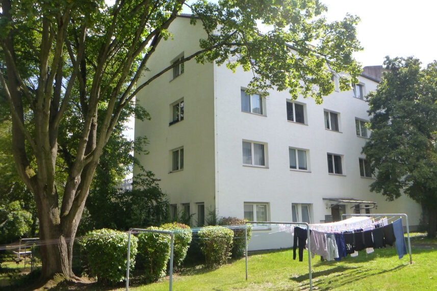Wohngebäude aus den 1950er Jahre mit grünem Innenhof und Wäsche auf einer Wäscheleine