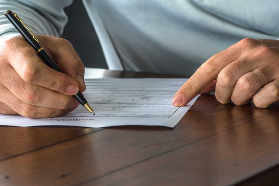 Χέρια κατά τη συμπλήρωση μιας φόρμας