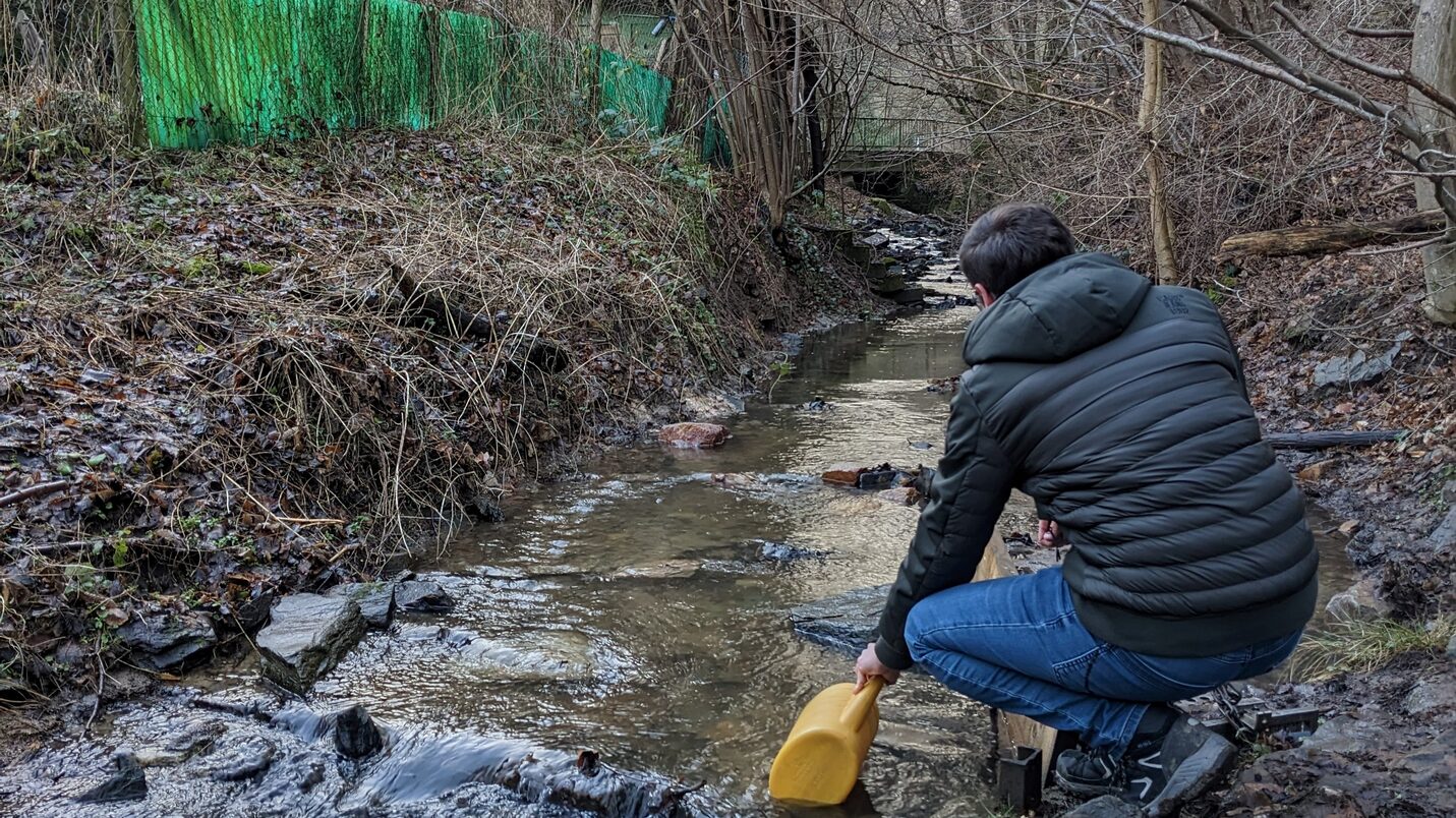 Adam sulama bidonuyla dereden su çekiyor
