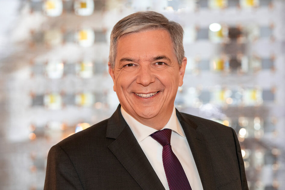 Mann mit grauen Haare in Anzug mit Schlips.