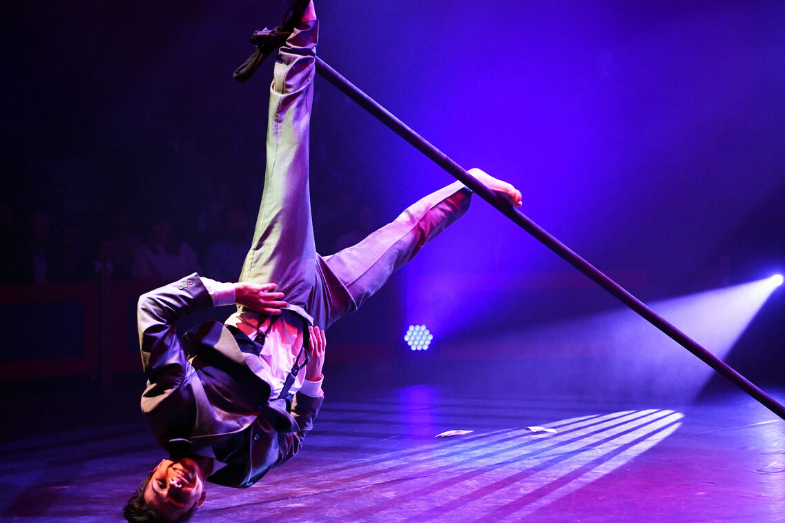 Artist Justin Philadelphia hängt kopfüber am Chinese Pole