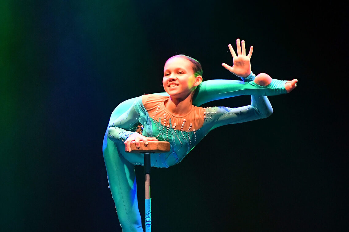 Artistin Viktoria Voitko auf einem Equilibristik-Podest lächelt ins Publikum